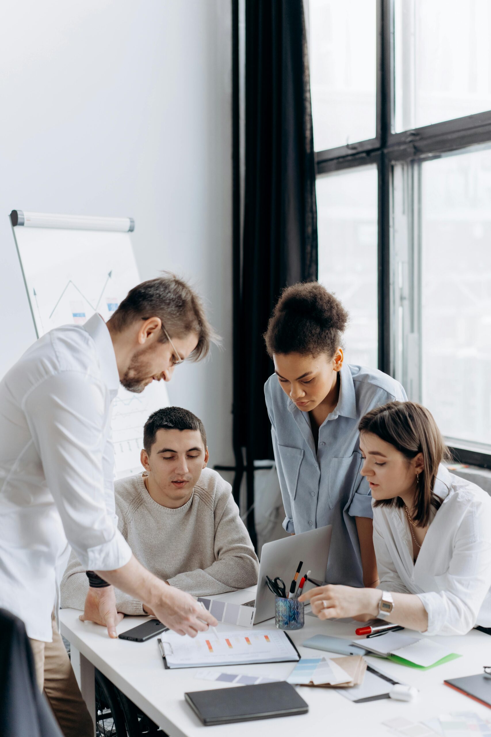 Group of professionals discussing ideas in a bright, modern office setting.